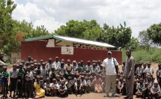 Deo, headmaster and pupils with Maendeleo toilet