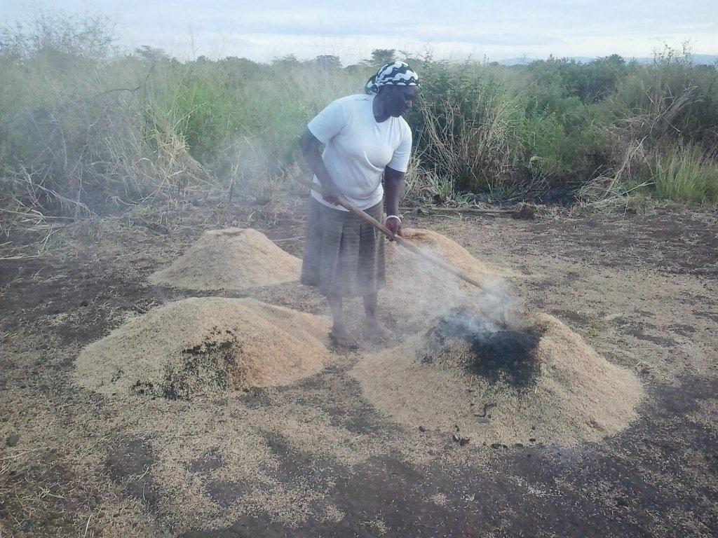 Naomi making rice hull charcoal