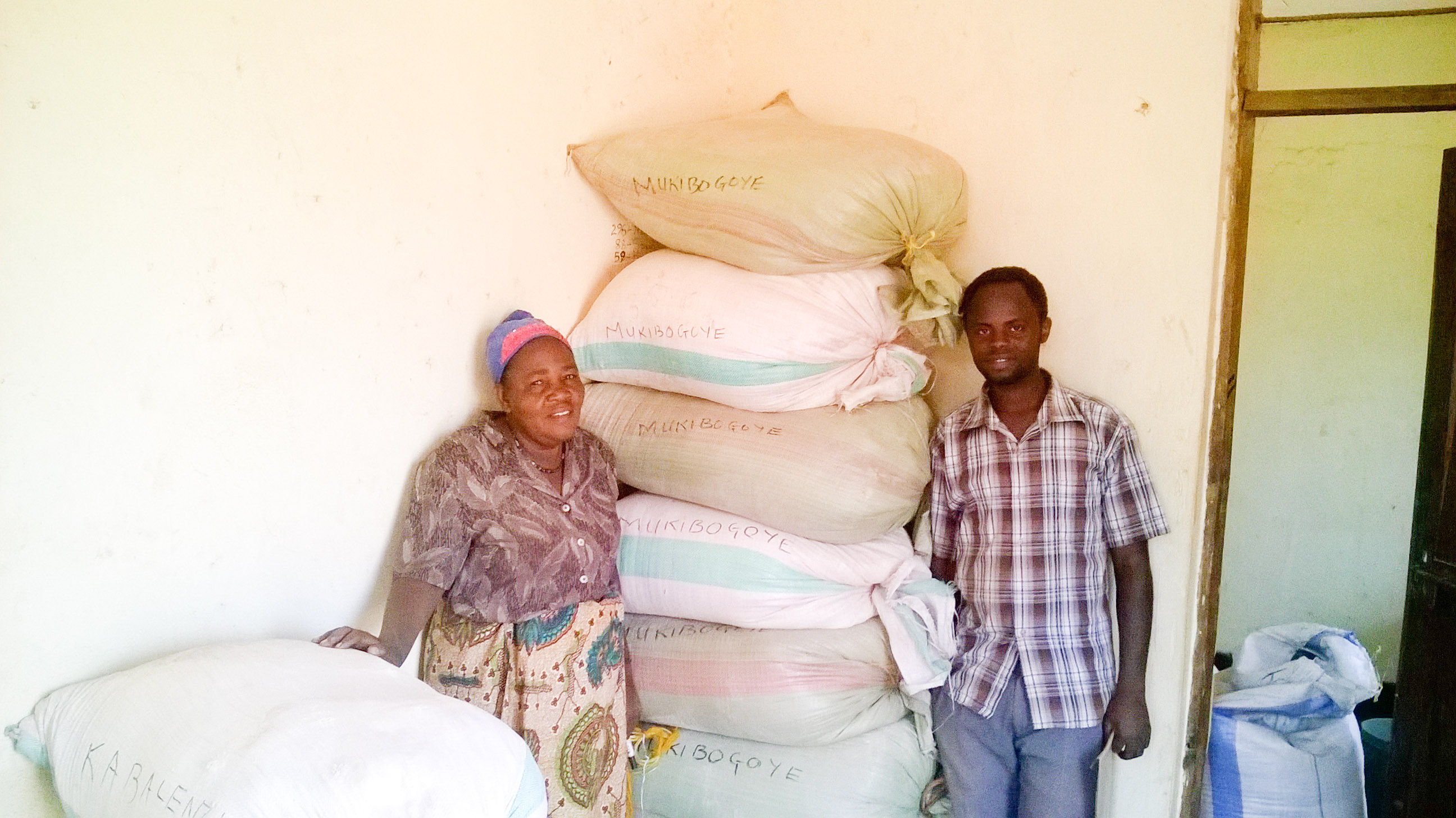 Lydia, program coordinator, and Daudi, assistant coordinator, next to the bags of breakfast nutrition mix they have just prepared.