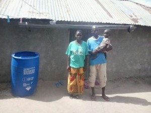 Three of four family members outside their home in Kindwitwi.