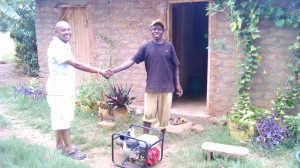 The father (right) after purchasing a water pump with a loan from Better Lives and Tupendane.