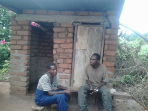 GMM mother and father in front of their newly finished toilet and bathing room.