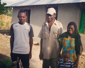 Jumanne and his family with their water connection and new home