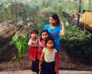 MSO, her two children, and niece in front of their organic vegetable garden