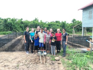 Family and students in front of completed organic vegetable garden