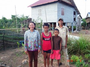 PYP family in front of their home and organic vegetable garden